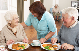 A woman assisting an old man and woman